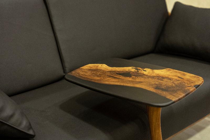 black resin walnut end table over a black sofa.