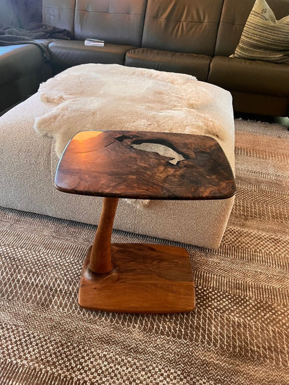 good looking c shaped end table made of walnut in a big living room.