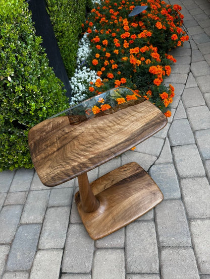 beautiful end table near to flowers pictured on a sunny beatiful day.