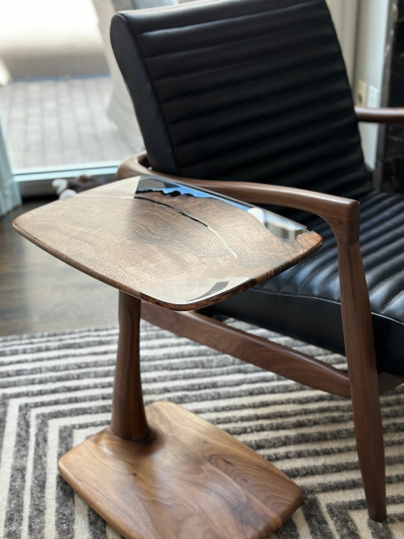 gorgeous designed  end table by a walnut chair.