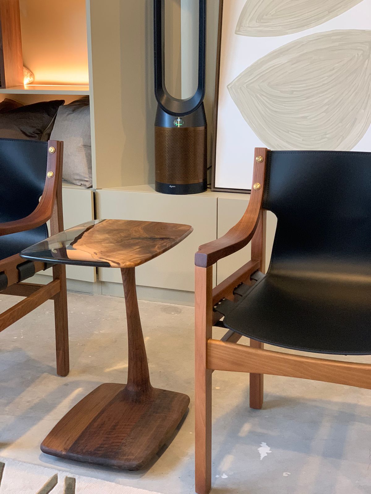 c shaped end table between two walnut armchair.